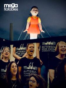 Giant squid games doll inflatable floating over battersea power station 