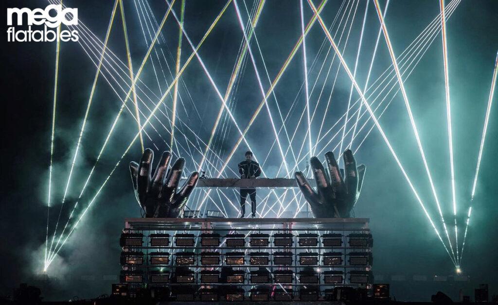 Two enormous mirrored inflatable hands rise dramatically on stage amid beams of light and smoke effects. Designed by Mega Inflatables, this stunning installation was created for a major music event, adding an epic visual spectacle to the performance.